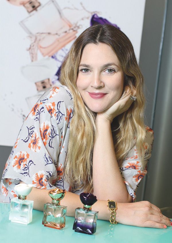 Drew Barrymore with her three fragrances Radiant, Cherished and Sultry